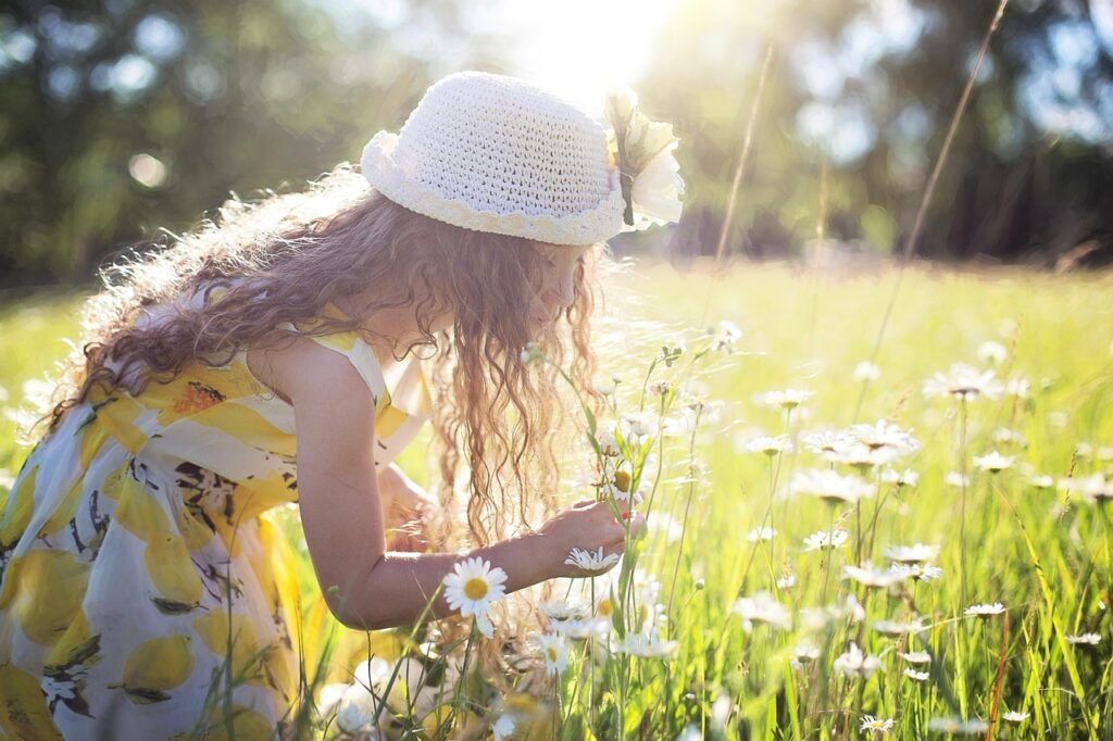 女の子が花を摘んでいる写真。
