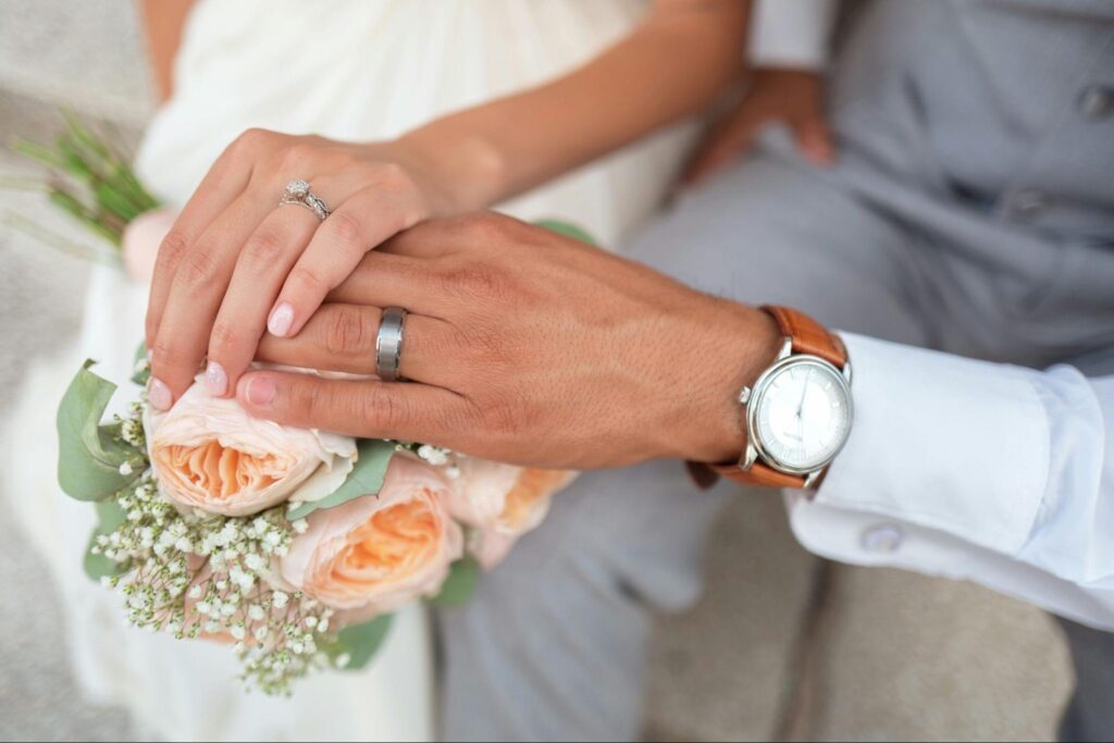 花嫁と花婿が、結婚指輪をはめた手を重ね合わせている写真。