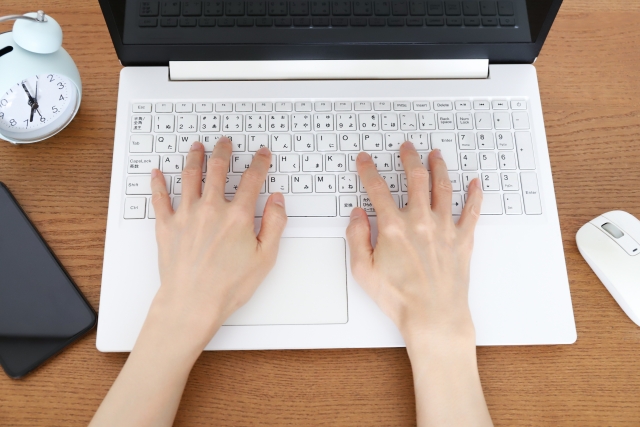 ノートPCでタイピングしている写真